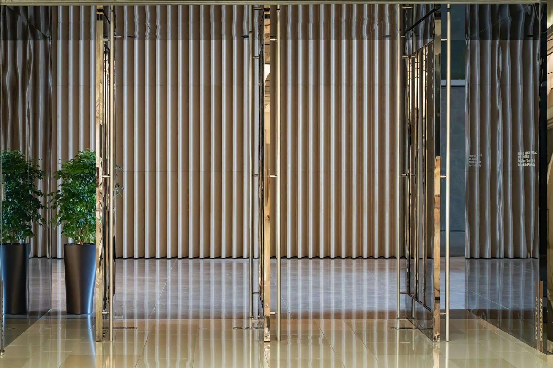 Entrance foyer with vertical timber slats, sheer curtains and potted plants