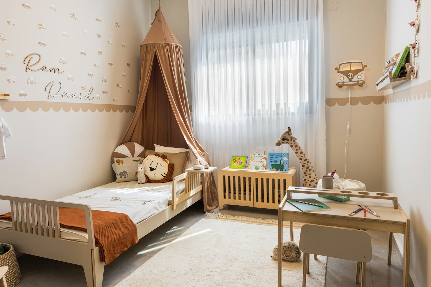 Child’s bedroom with a canopy bed, wooden desk and soft neutral colours