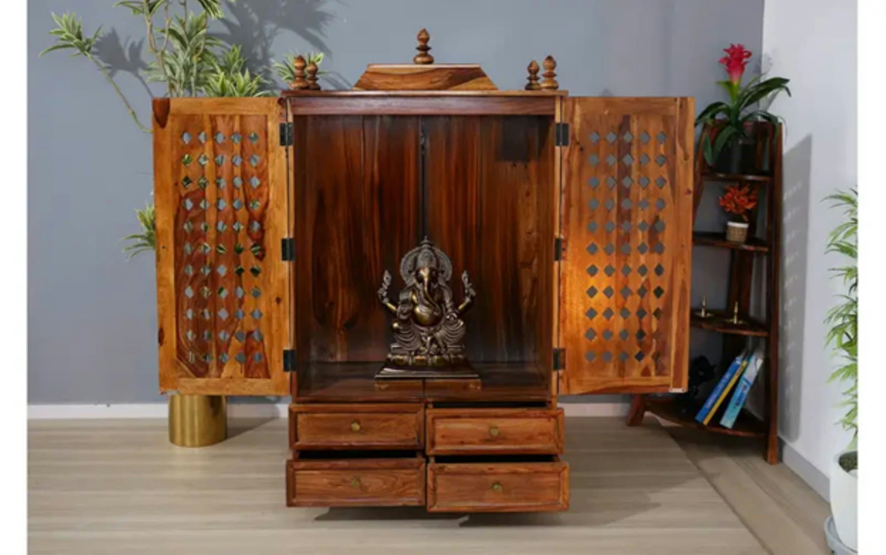 Carved wooden home mandir with a Ganesha idol and brass diyas
